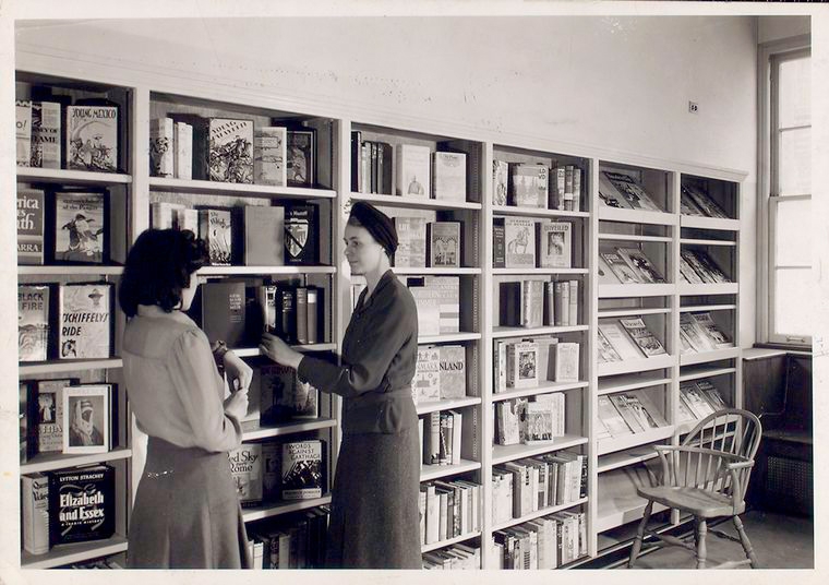 "Librarian with young reader in Browsing Room of the Nathan Strauss Branch for Young People" The New York Public Library Digital Collections.